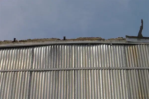 damaged insulation flashing along roof of storage tank