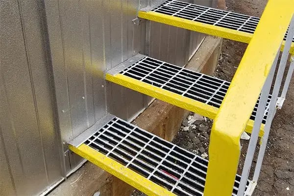 metal stairs protruding from metal jacketed insulation on storage tank