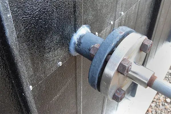 valve protruding from storage tank insulation sealed with caulk