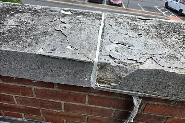 deteriorated capstone with surface delamination and environmental stains