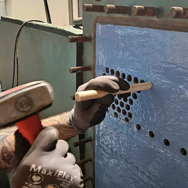 corks are tapped into heat exchanger tubes after coating has cured
