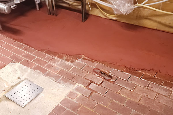 acid brick repair around drain in progress