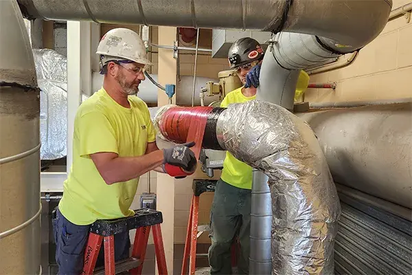 metal pipe repair workers using superwrap composite