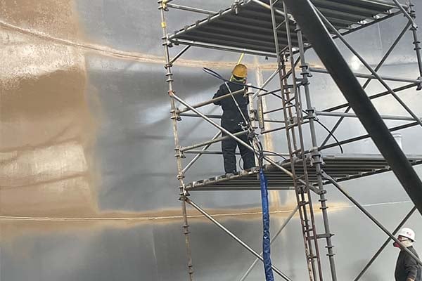 spray application of protective coating to interior tank walls