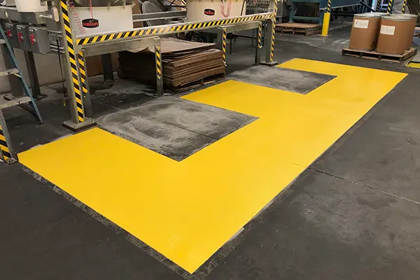 yellow anti-slip floor coating in manufacturing work area in manufacturing facility
