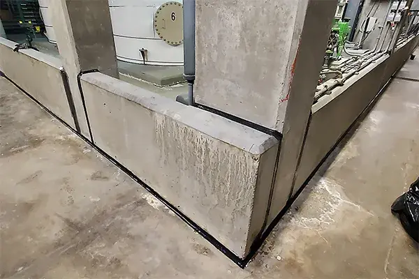 caustic containment area joint seam seal with elastomeric