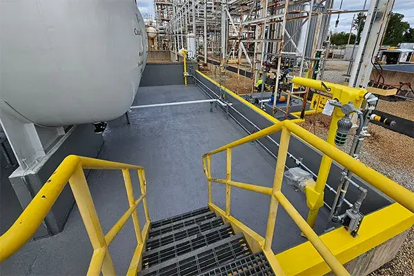 chemical processing secondary containment area concrete restoration and protective coating finished application showing sodium hydroxide storage tanks in a bund area