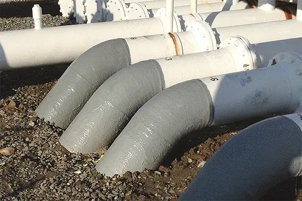 soil line corrosion repair finished result showing coated pipes entering the ground