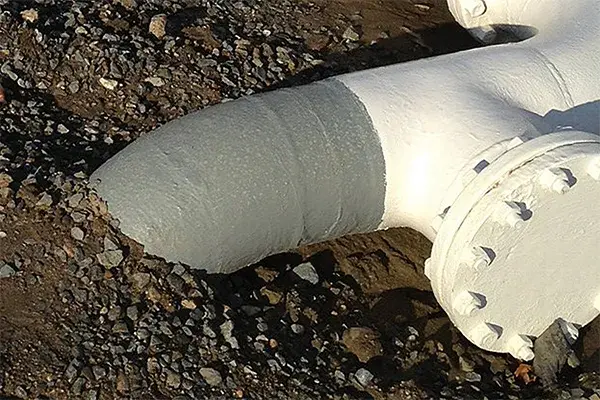 soil line pipe corrosion repair showing steel pipe entering below ground in moist soil